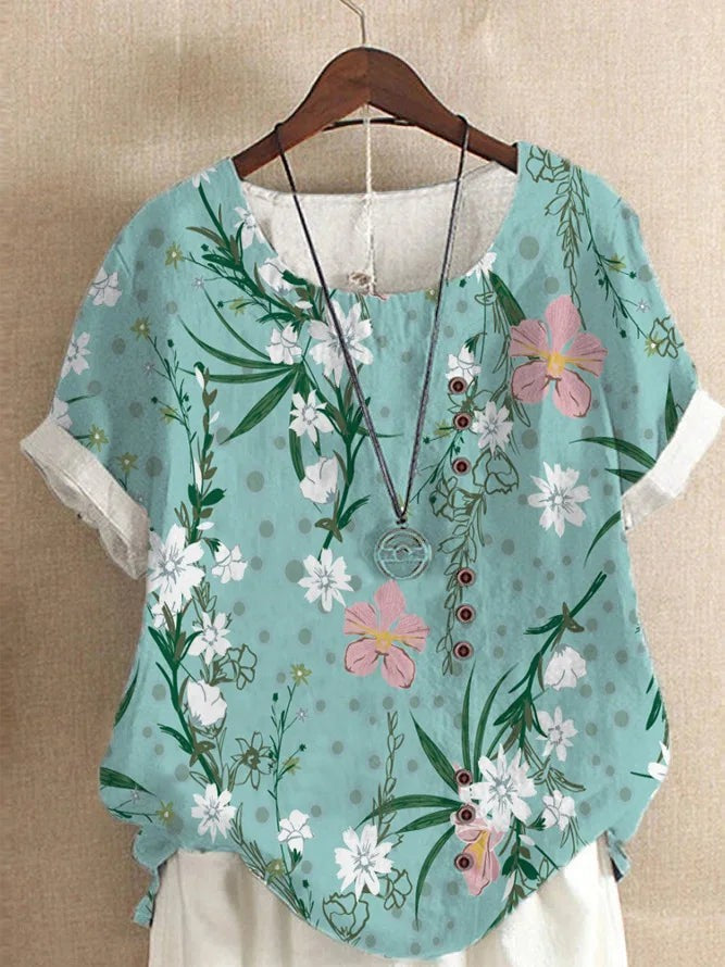 AKJ Fashion blouse effet lin vert à fleurs de glycines violettes et papillons, boutonnage décalé, manches courtes roulottées.