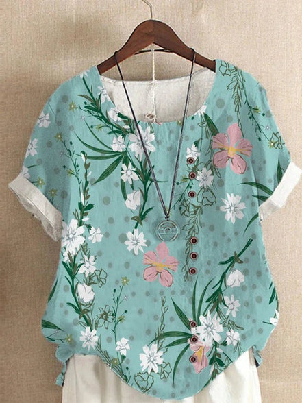 AKJ Fashion blouse effet lin vert à fleurs de glycines violettes et papillons, boutonnage décalé, manches courtes roulottées.
