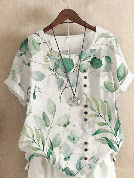 AKJ Fashion blouse blanche à imprimé feuillage vert, col rond, boutonnage décalé, manches courtes retroussées. Tissu effet lin.