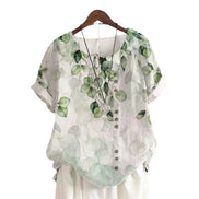 AKJ Fashion blouse verte à imprimé feuilles d'eucalyptus, col rond, manches courtes retroussées, boutonnage décalé.