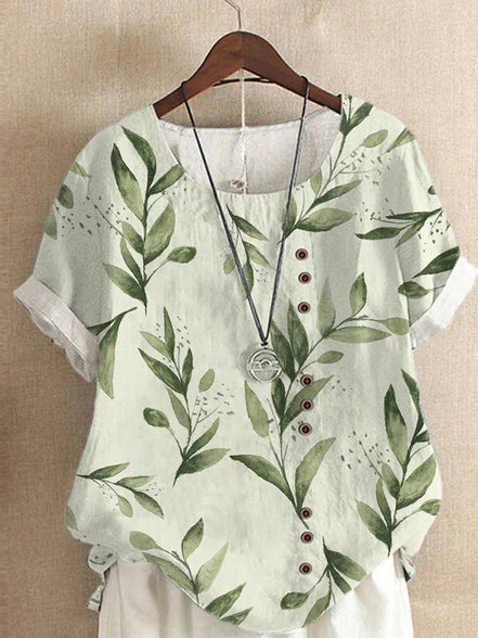 AKJ Fashion blouse verte à imprimé feuilles et fleurs, col rond, manches courtes retroussées, boutonnage décalé.