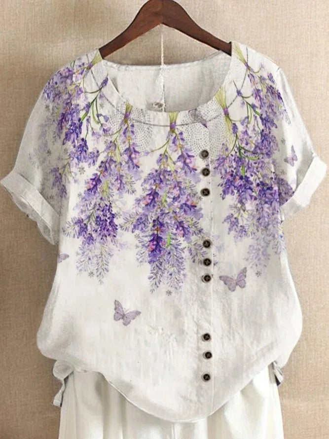 AKJ Fashion blouse blanche à imprimé glycines violettes et papillons, effet lin, manches courtes retroussées, boutonnage décalé.