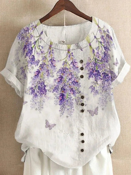 AKJ Fashion blouse blanche à imprimé glycines violettes et papillons, effet lin, manches courtes retroussées, boutonnage décalé.