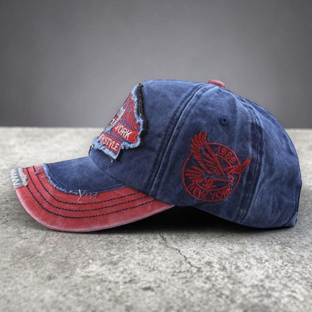 AKJ Fashion blue denim baseball cap with red embroidery and distressed details. Adjustable strap for a comfortable fit.