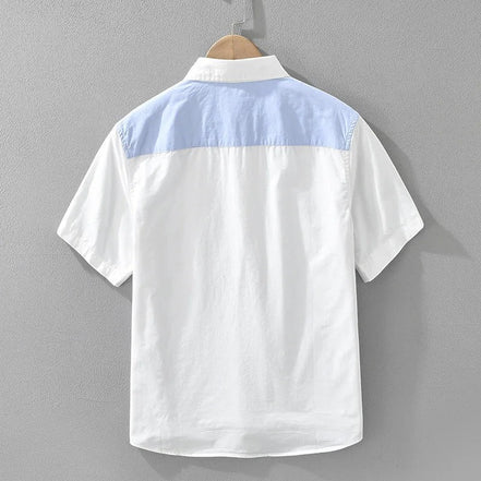 Chemise AKJ Fashion homme blanche à manches courtes, avec un empiècement bleu ciel sur le haut du dos. Popeline de coton.