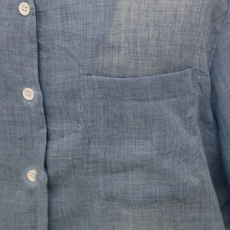 Chemisier AKJ Fashion en lin bleu clair à manches longues avec poche poitrine et boutons blancs.