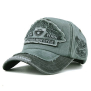 AKJ Fashion grey washed cotton denim baseball cap with vintage New York patches and adjustable strap.