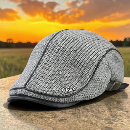 AKJ Fashion grey knit flat cap with faux leather trim and decorative 'Live' emblem. Adjustable buckle strap at back.