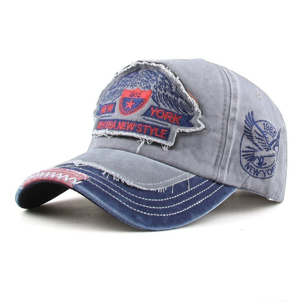 AKJ Fashion grey distressed cotton baseball cap with New York patches and adjustable strap.