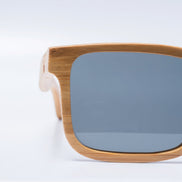 Lunettes de soleil géométriques AKJ Fashion en bambou FSC, verres polarisés gris, monture carrée naturelle.