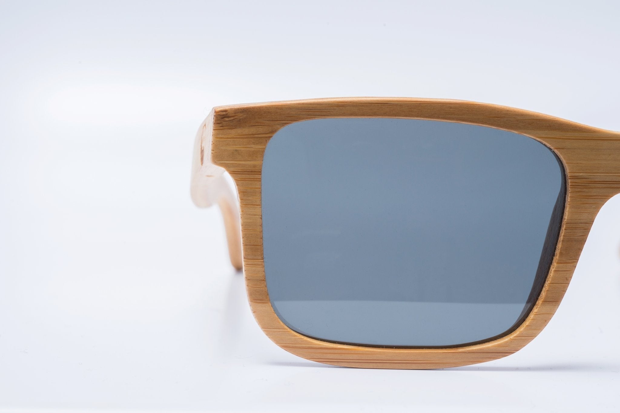 Lunettes de soleil géométriques AKJ Fashion en bambou FSC, verres polarisés gris, monture carrée naturelle.