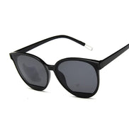 Lunettes de soleil AKJ Fashion rétro noires, forme cat-eye, verres miroir, style 70s.