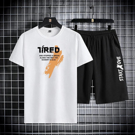 AKJ Fashion white t-shirt with black graphic text and orange brush stroke, paired with black athletic shorts with white text.