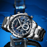 Montre AKJ Fashion CURREN argent, bracelet acier inoxydable, cadran bleu avec aiguilles lumineuses et date automatique. Style moderne.