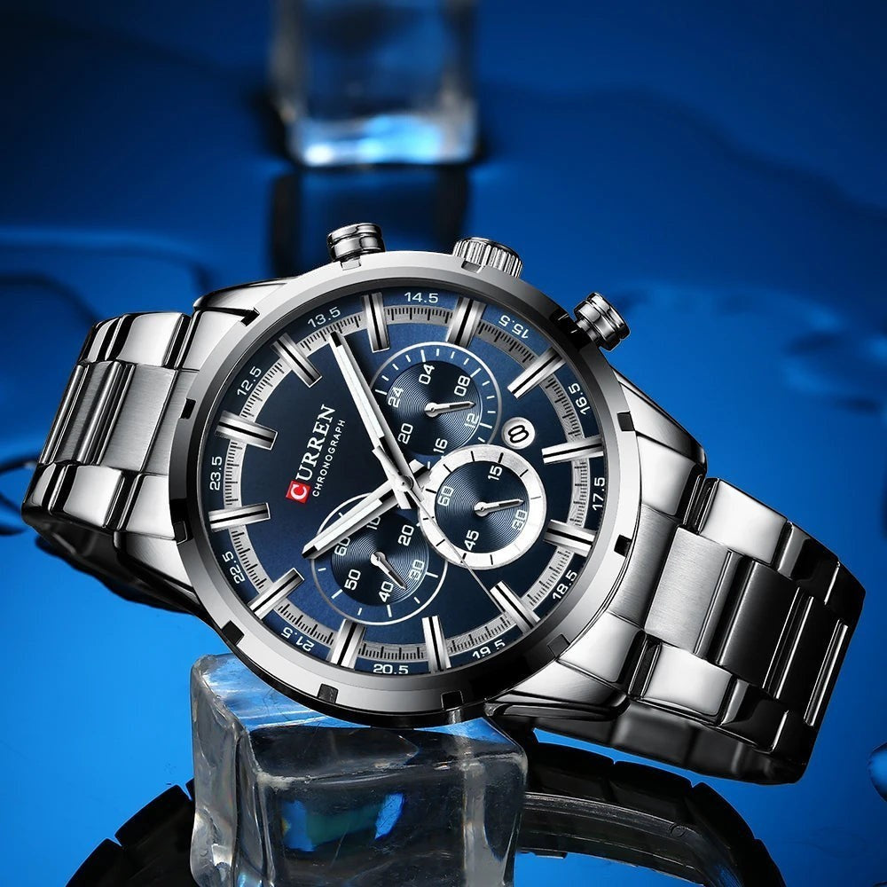 Montre AKJ Fashion CURREN argent, bracelet acier inoxydable, cadran bleu avec aiguilles lumineuses et date automatique. Style moderne.