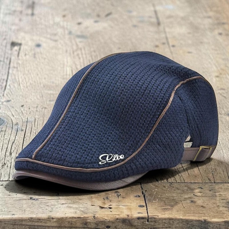 AKJ Fashion navy blue knit flat cap with brown leather trim and decorative emblem