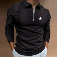 Polo AKJ Fashion homme noir à manches longues, col zippé, tissu texturé rayé, logo discret sur la poitrine.