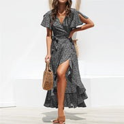 AKJ Fashion robe longue noire et blanche à imprimé floral, col en V, manches courtes fendues, ceinture à nouer, fente haute sur le devant.
