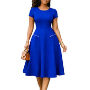 AKJ Fashion robe midi bleue à manches courtes, col rond, coupe évasée et poches zippées. Tissu structuré.