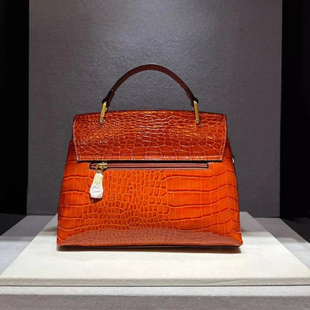 Sac à main AKJ Fashion en cuir de vachette orange motif serpent, chic et moderne, avec poignée et bandoulière.