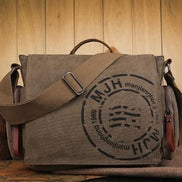 Sac bandoulière AKJ Fashion en toile vintage kaki, avec logo rond noir et bandoulière réglable.