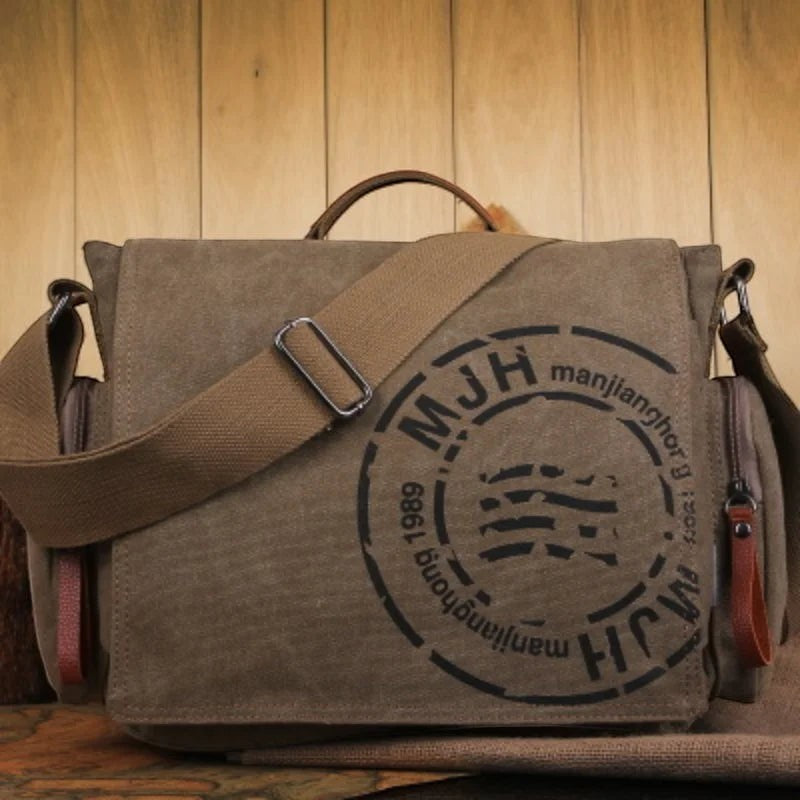 Sac bandoulière AKJ Fashion en toile kaki, style vintage, avec logo MJH et bandoulière réglable.