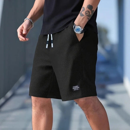 AKJ Fashion short d'été noir homme, coupe droite, tissu gaufré léger, ceinture à cordon, poches latérales.